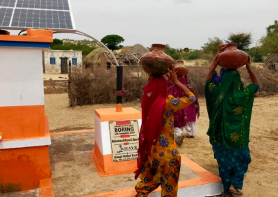 Women carrying vessels to get water from village well